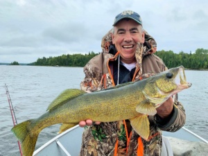 A man holds a large walleye fish that he's caught